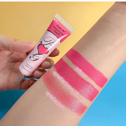 Tube de gloss rose avec un motif en forme de cœur présenté avec des échantillons de couleur sur la peau.