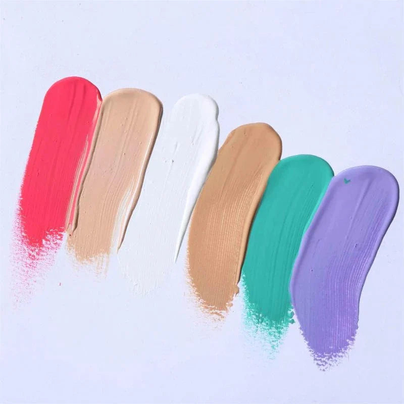 Échantillons de maquillage ou de peinture en rouge, beige, blanc, beige, sarcelle et violet, disposés en diagonale à l’aide d’un pinceau.