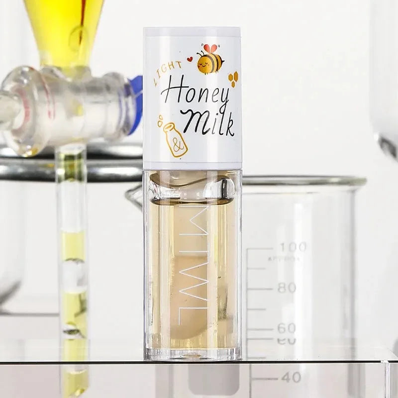 Bouteille transparente étiquetée ’Honey Milk’ avec un dessin d’abeille et un liquide de couleur claire à l’intérieur.