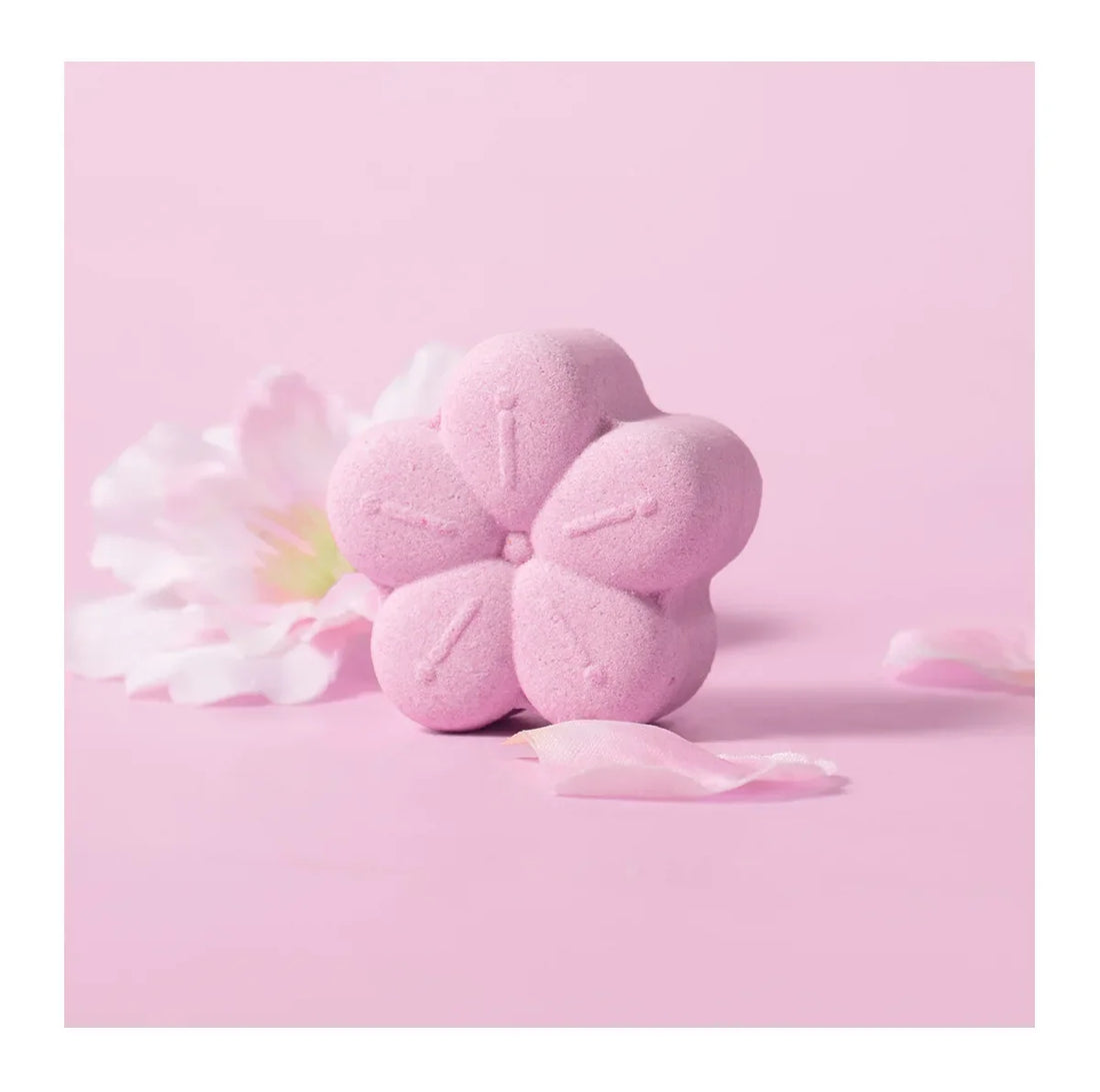 Bombe de bain ou savon en forme de fleur rose sur fond rose.