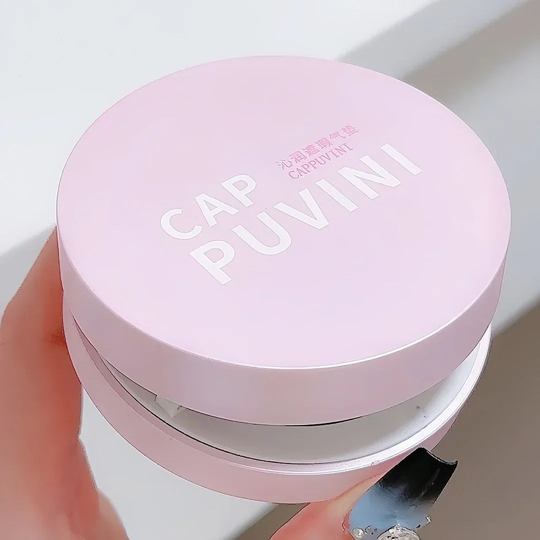 Poudrier circulaire rose étiqueté ’Cap Puvini’.