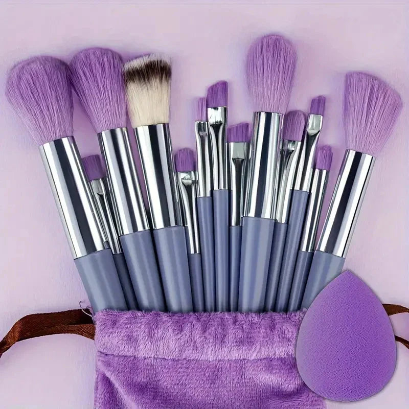 Set de pinceaux de maquillage violet avec poignées argentées et éponge beauty blender assortie.