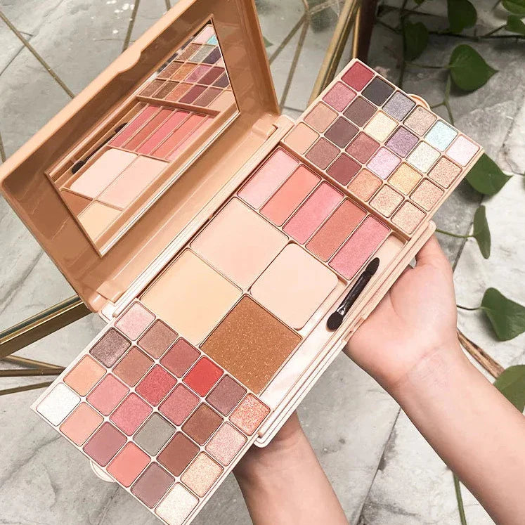 Palette de maquillage contenant des ombres à paupières, des fards à joues et des bronzeurs de couleur nude, rose et bronze.