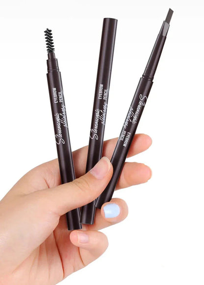 Main tenant trois crayons de maquillage pour sourcils brun foncé.