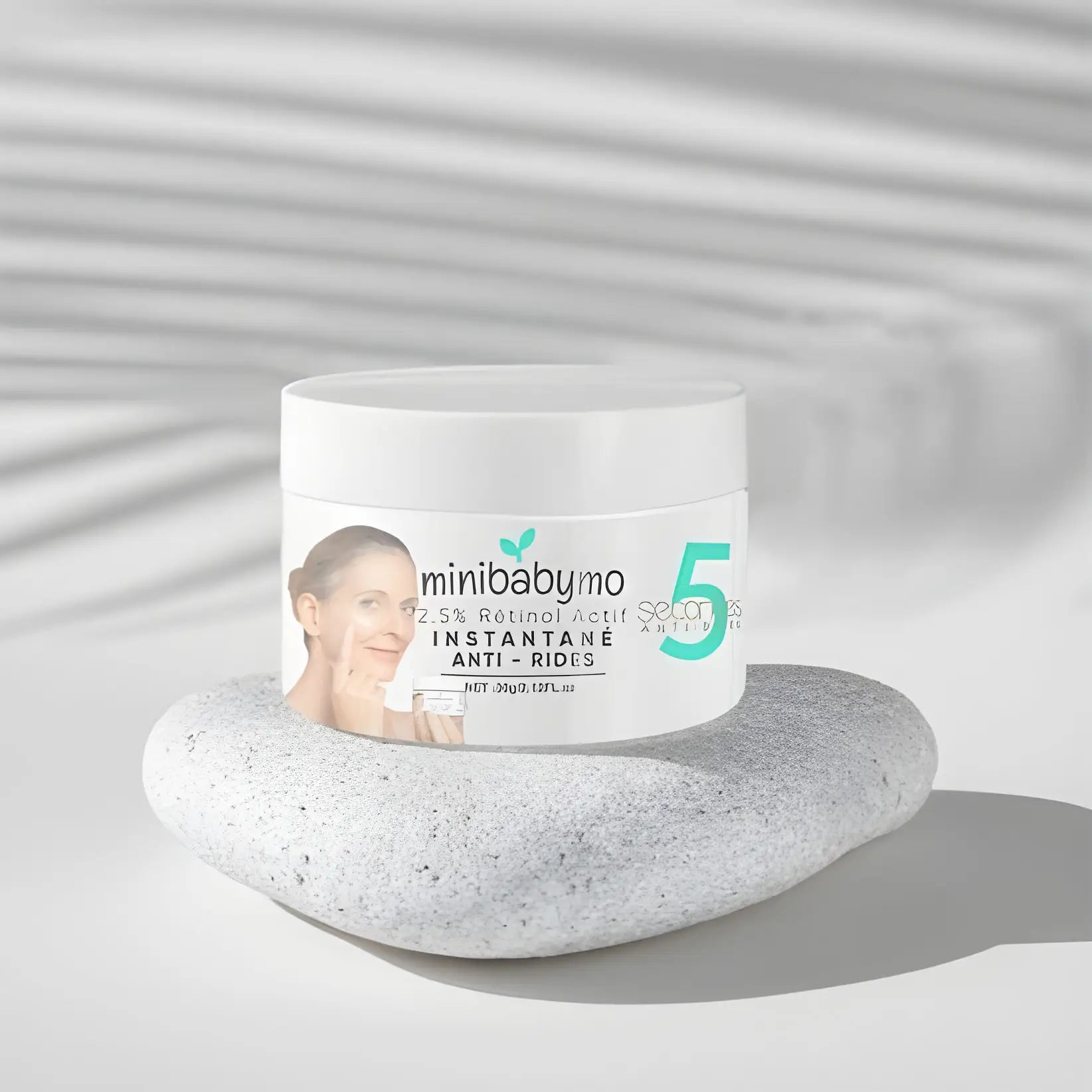 Pot de crème anti-âge Minibaby 5 posé sur une pierre lisse.