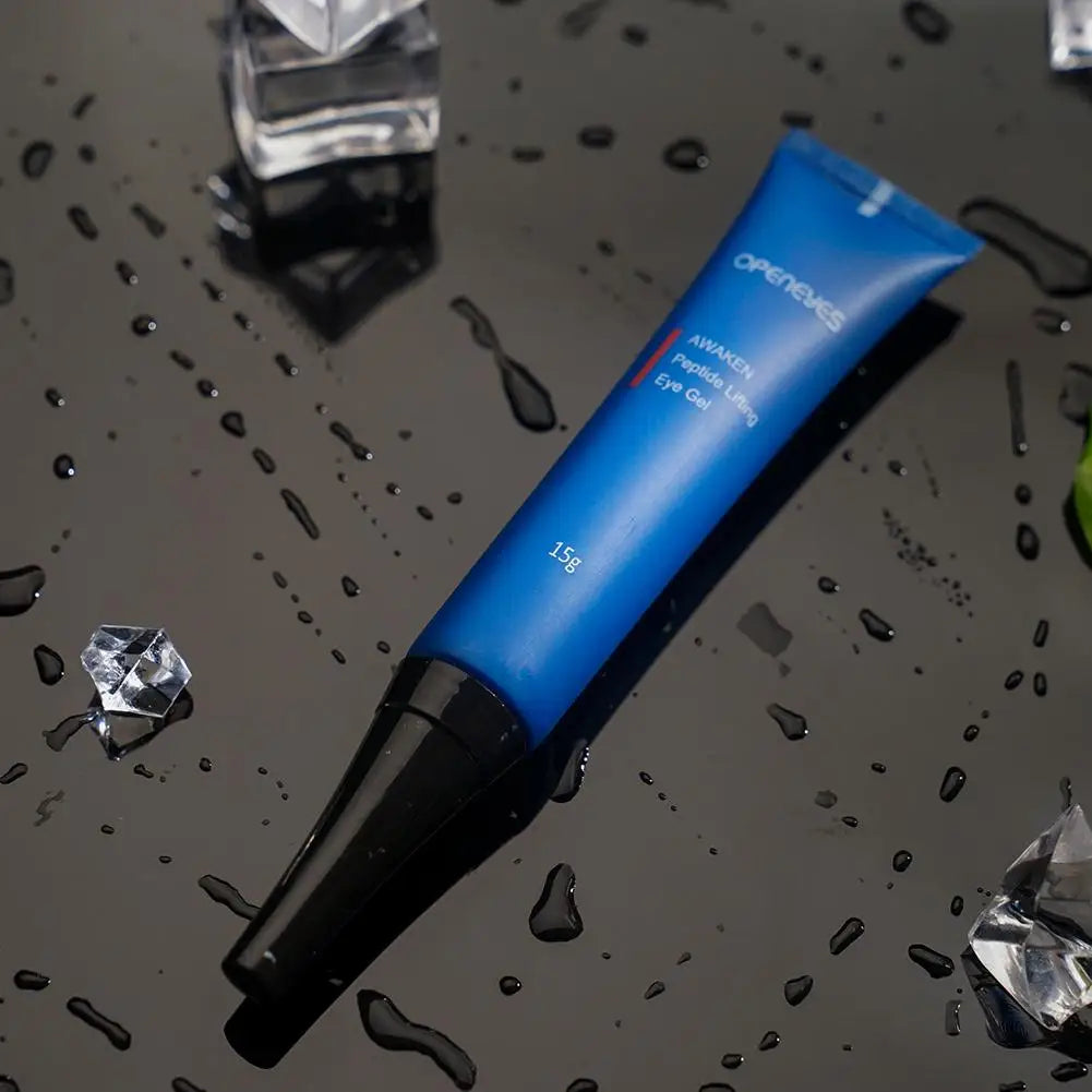 Tube cosmétique bleu et noir posé sur une surface humide.