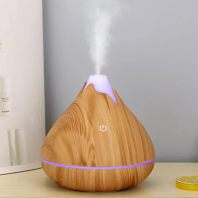 Diffuseur d’huiles essentielles en bois avec éclairage LED violet et vapeur d’eau.