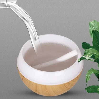 Un humidificateur sphérique en bois et blanc dans lequel coule de l’eau.