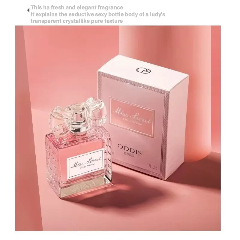 Un flacon de parfum taillé en cristal avec un liquide rose et son coffret de vente assorti.