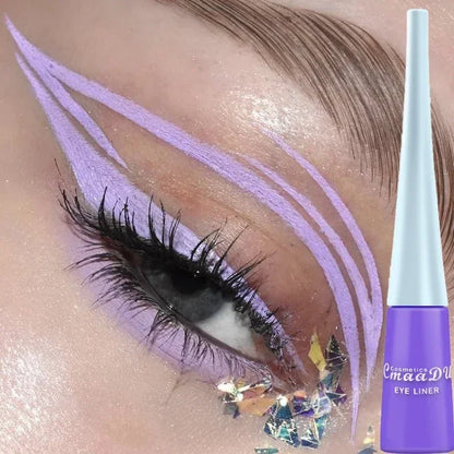 Eyeliner liquide violet avec cristaux décoratifs appliqués en forme d’ailes artistiques.