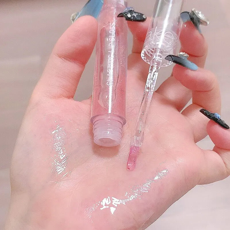 Échantillons et tubes de gloss transparents sur une main aux ongles décoratifs.