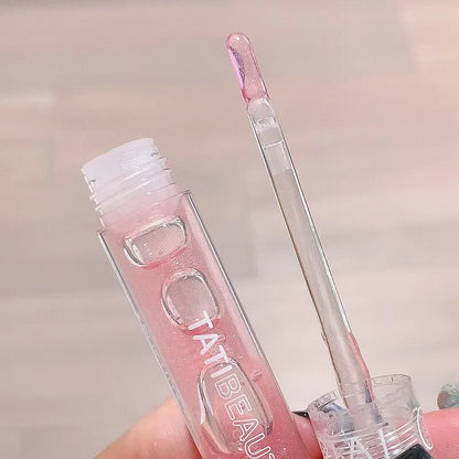 Tube de gloss transparent avec applicateur teinté rose.