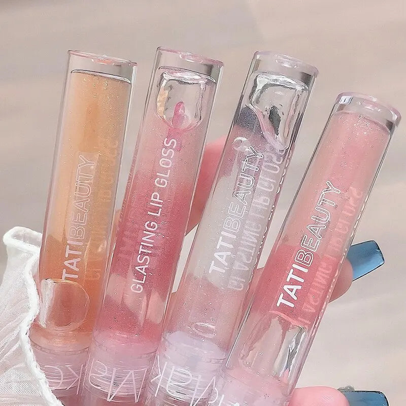 Quatre tubes de gloss rose alignés les uns à côté des autres.