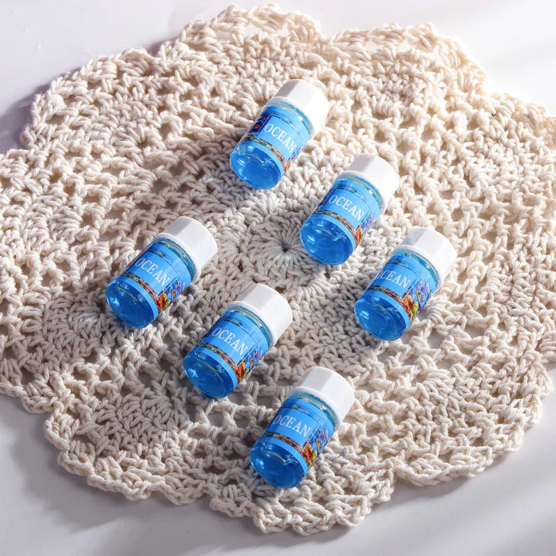 Six bouteilles en verre bleu disposées sur un napperon en crochet.