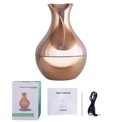 Diffuseur d’huiles essentielles en forme de vase en or rose avec bouton d’alimentation.