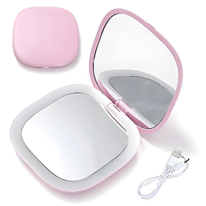 Miroir de maquillage rose compact avec lumières LED intégrées et câble de chargement USB.