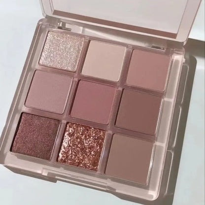 Palette d’ombres à paupières à neuf composants, avec des teintes roses, mauves et or rose.