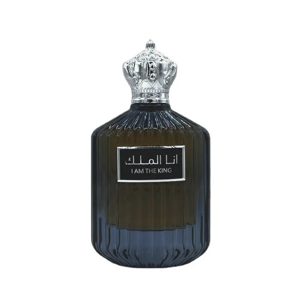 Flacon de parfum en verre foncé avec un bouchon argenté en forme de couronne et un texte arabe sur l’étiquette.