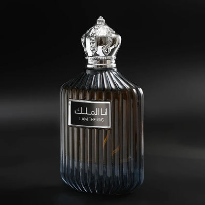 Flacon de parfum orné d’une couronne argentée et d’un texte arabe sur l’étiquette.