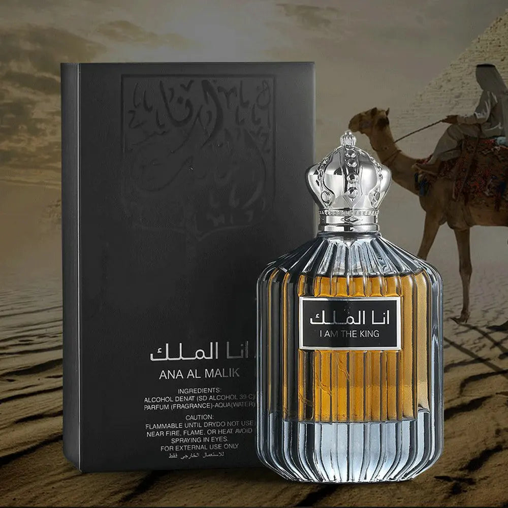 Flacon de parfum en verre orné d’un texte arabe et d’un bouchon argenté en forme de couronne, accompagné de sa boîte d’emballage.