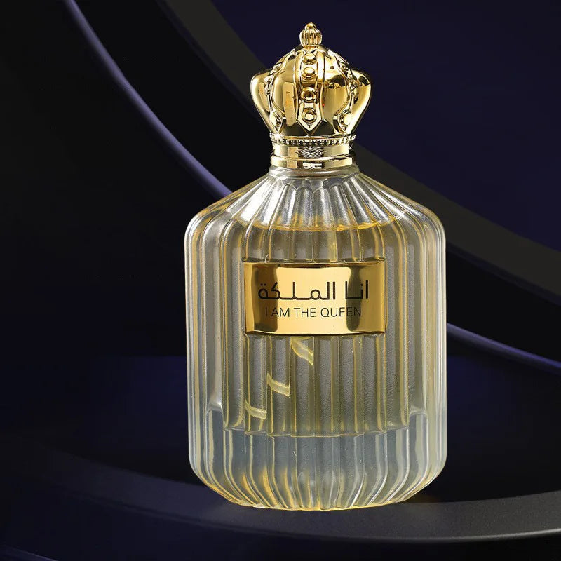 Flacon de parfum en verre orné d’un bouchon en forme de couronne dorée et d’un texte en arabe sur l’étiquette.