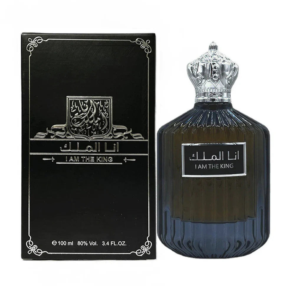 Un flacon de parfum en verre bleu foncé avec un bouchon couronne argenté et sa boîte d’emballage noire assortie avec un texte en arabe.