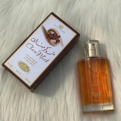 Flacon de parfum et sa boîte d’emballage avec un texte arabe sur une surface blanche.