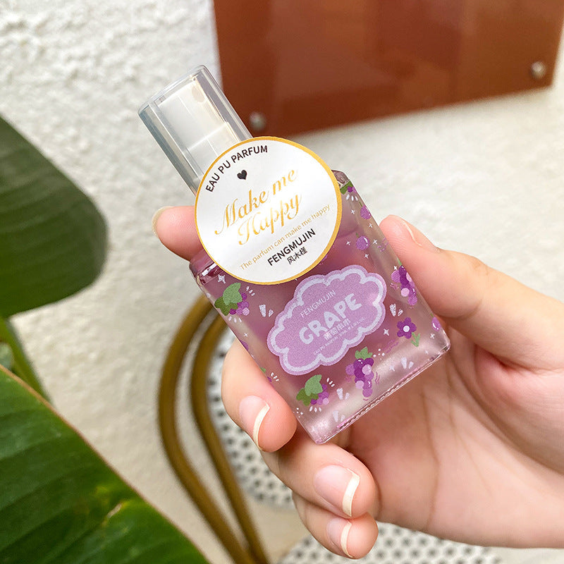 Un flacon de parfum violet parfumé au raisin avec un bouchon doré.