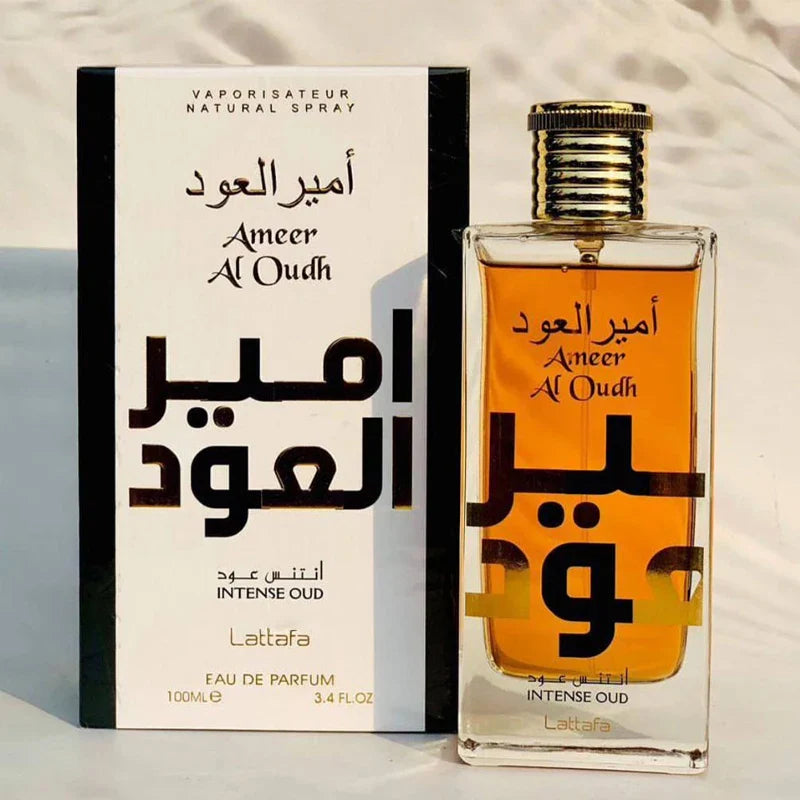 Un flacon de parfum et une boîte portant l’inscription ’Ameer Al Oudh’ en arabe et en anglais.