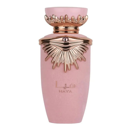 Flacon de parfum rose avec un motif en forme de soleil doré et une couronne décorative.