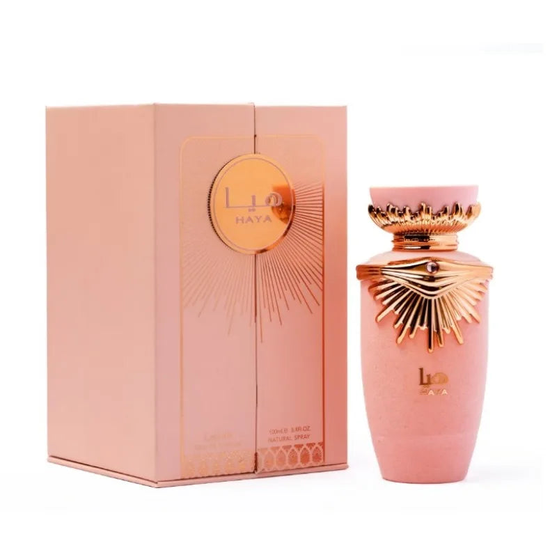 Flacon de parfum rose avec accents métalliques or rose et boîte d’emballage assortie.