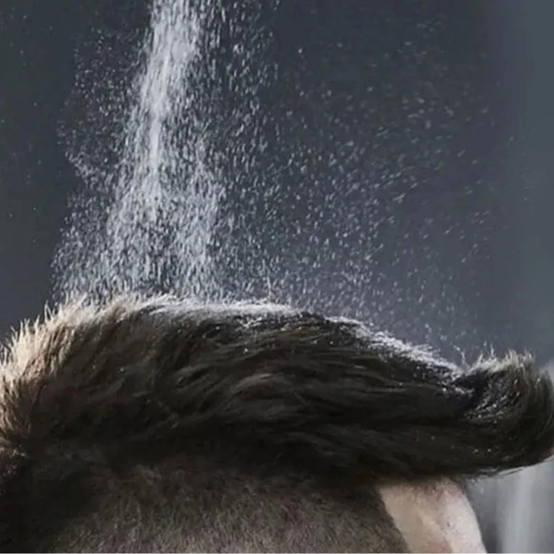 Vaporisateur d’eau tombant sur les cheveux noirs.