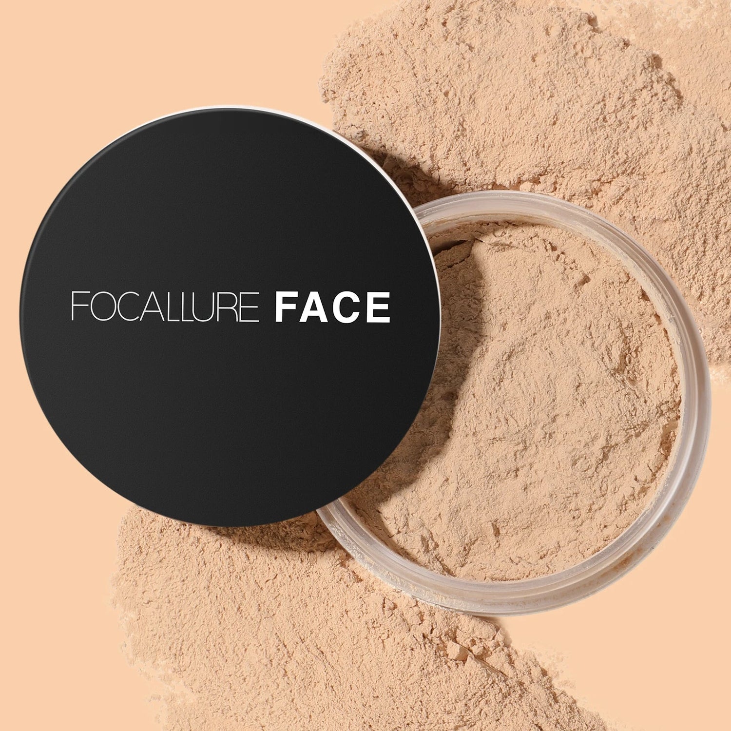 Contenant compact noir de la poudre libre Focallure Face avec de la poudre beige renversée autour.