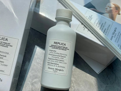 Flacon blanc du parfum Maison Margiela Replica avec un étiquetage minimaliste.