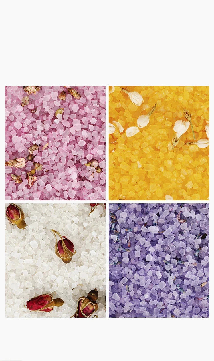 Quatre carrés de sels de bain colorés en rose, jaune, blanc et violet, parsemés de pétales de fleurs séchées.