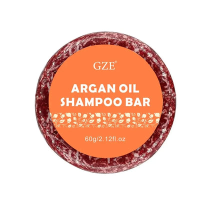 Barre de shampoing circulaire à l’huile d’argan avec une étiquette orange et une coloration brun-rouge.