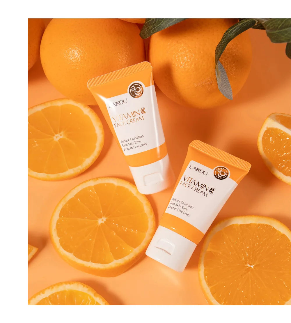 Deux tubes de soin à la vitamine C entourés de tranches d’orange fraîche.